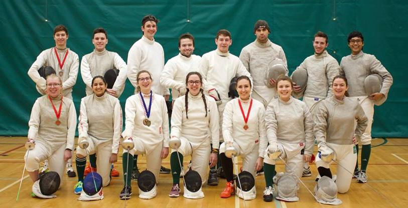 A group shot of numerous smiling fencing varsity athletes. 