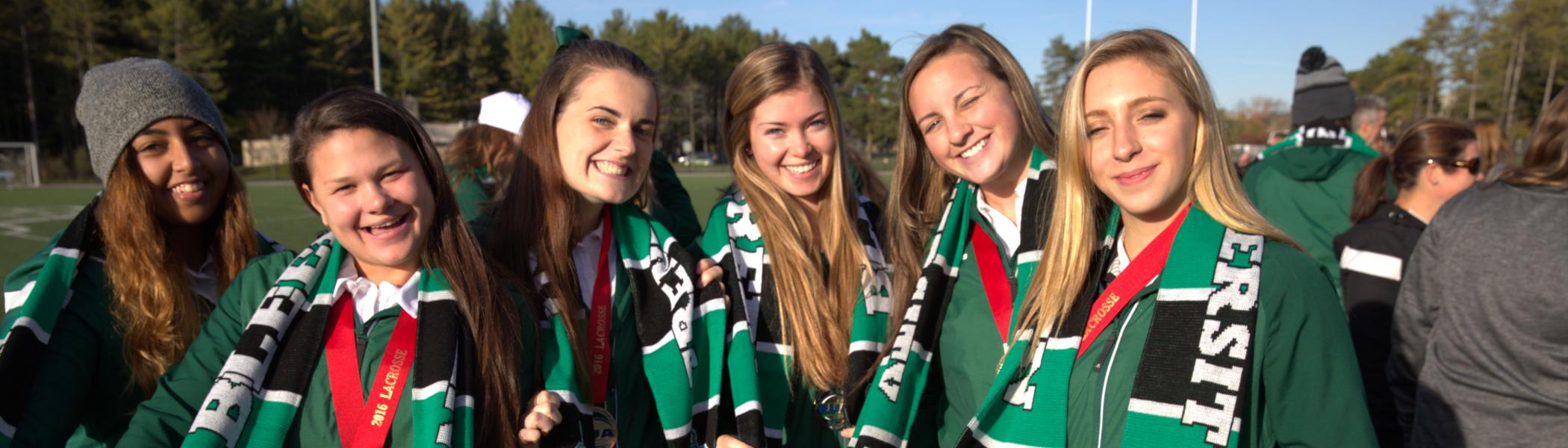 Women's Lacrosse team members smile with their OUA Bronze Medals